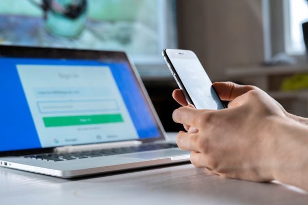 holding-a-phone-and-working-using-laptop-log-in-o-2025-01-27-04-05-23-utc