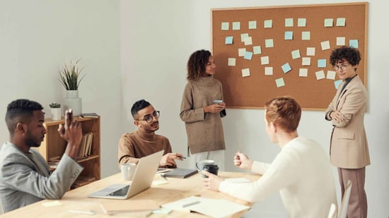 Team brainstorming in an office with sticky notes on a board, representing planning and collaboration for multi-party computation projects.