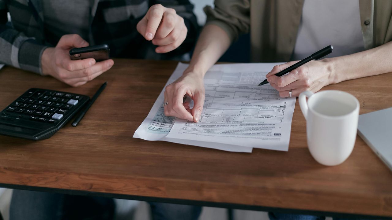 two persons doing tax control paperwork