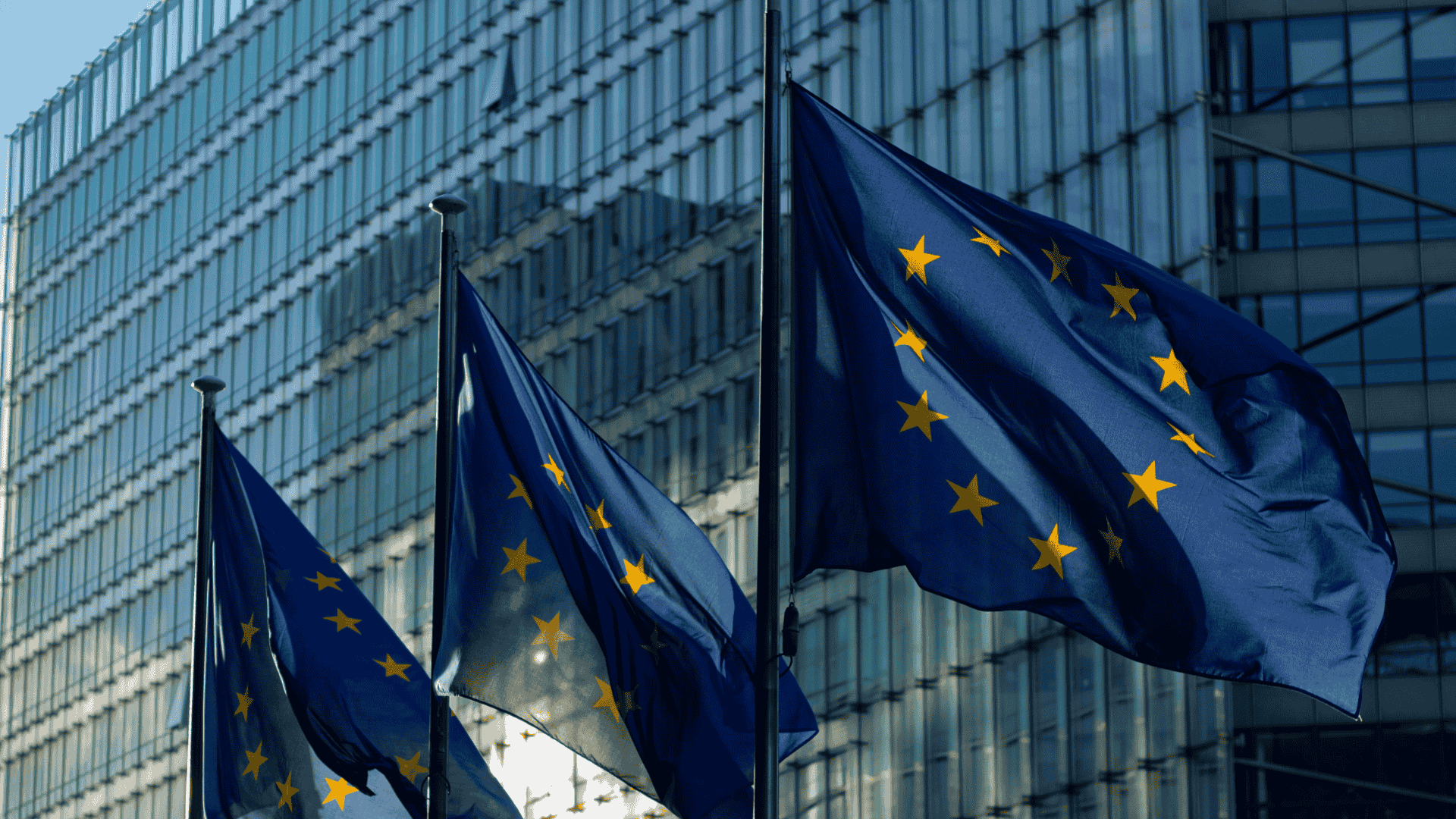 EU flags outside a government building, symbolizing the DORA regulation impacting financial institutions in 2025.