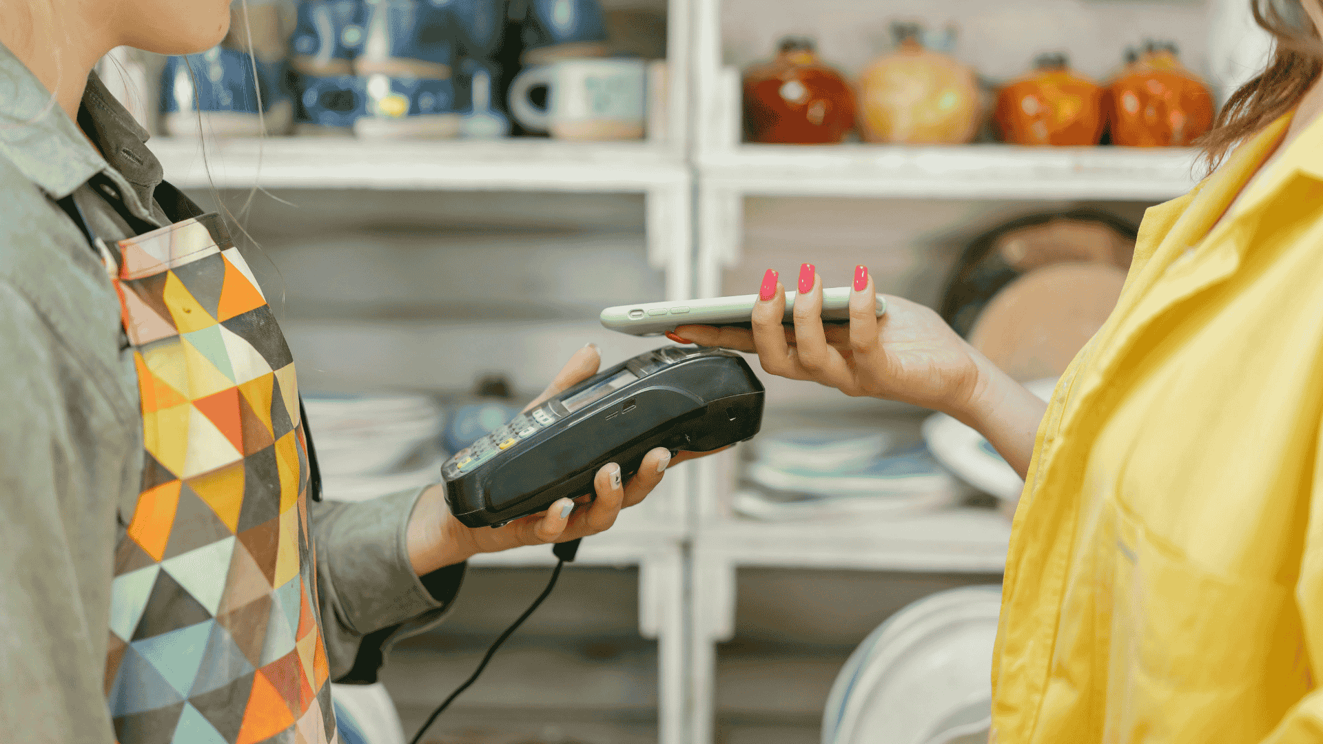 Smartphone contactless payment at a store, representing how interoperability works.
